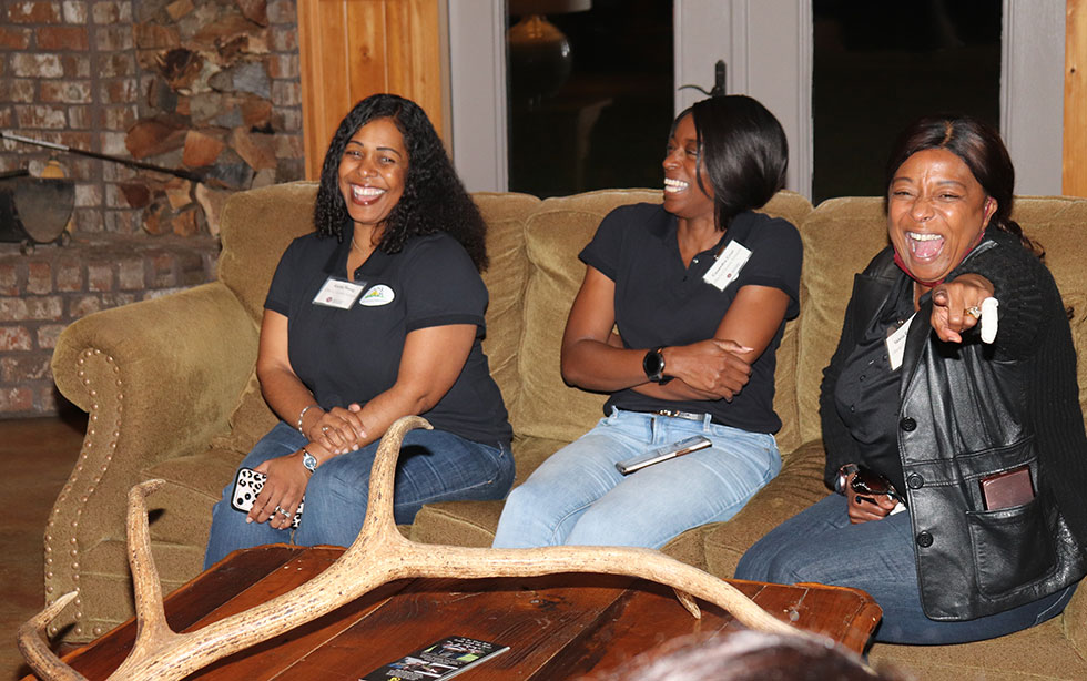 Three women laugh.